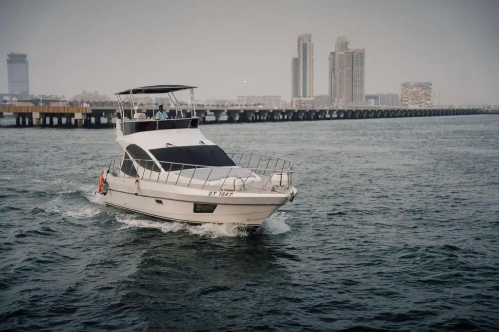 SH 88 Feet Yacht cruising past a city skyline in Dubai.